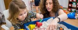 Specialist and child playing with sandbox